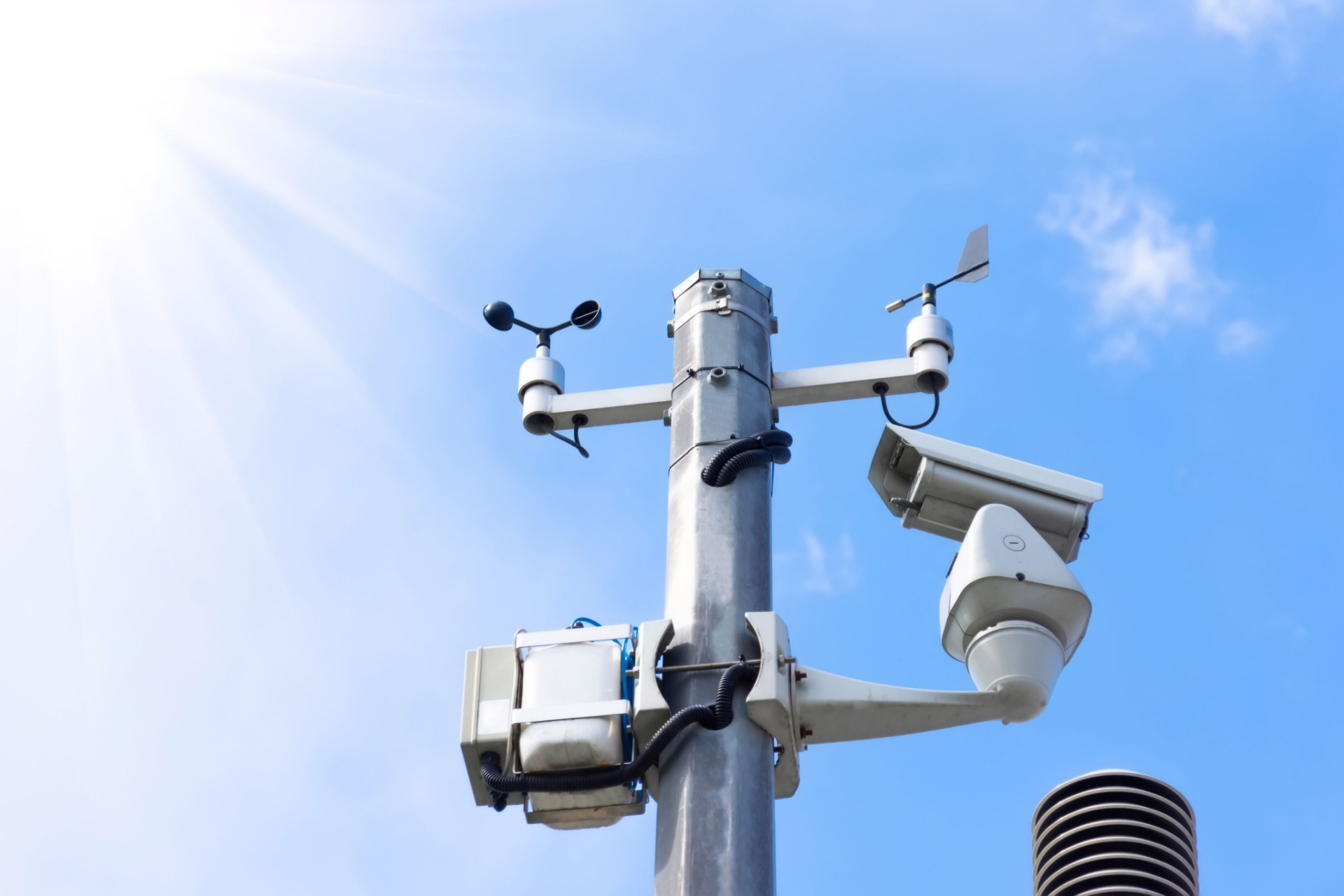 An automatic weather station with blue skies behind it